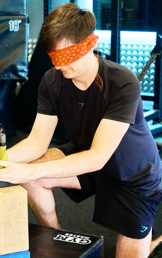 Member taking on a blindfolded kettlebell balance challenge at a members' games day