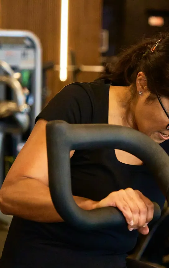 Member pushing through a bike session on the cardio floor at Avoya Fitness Bromley