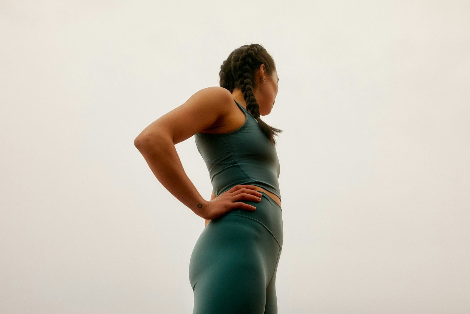 A member standing composed, hands on hips, against a soft open sky