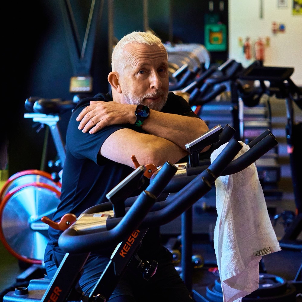 An Avoya member resting on a training bike with a towel