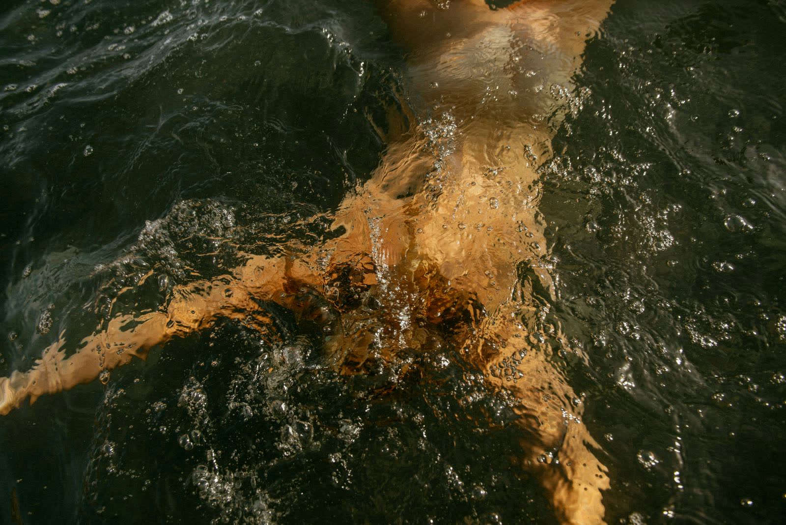 Swimmer mid-stroke in dark open water