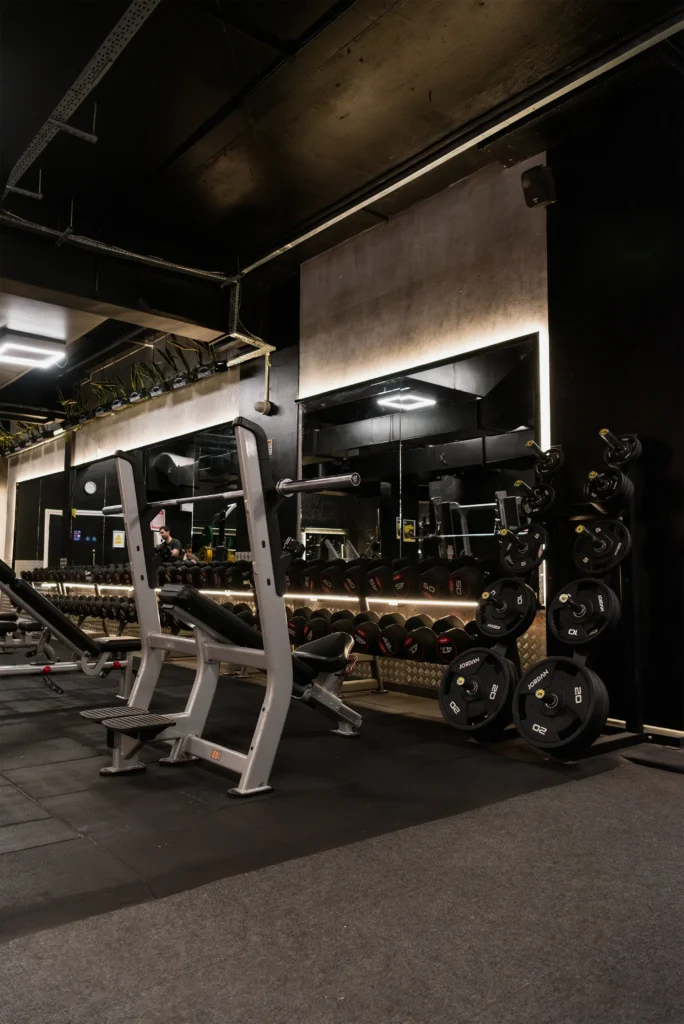 Free weight area featuring dumbbell racks and large wall mirrors.