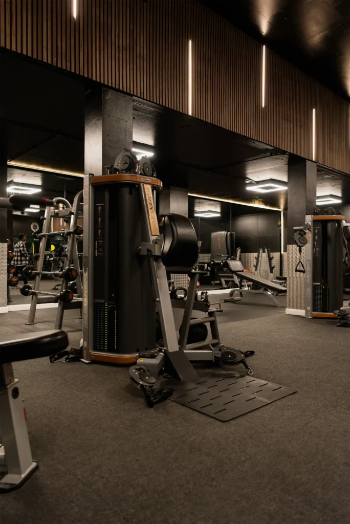 Wide view of the Avoya Fitness interior with dark ceilings and strip lighting.