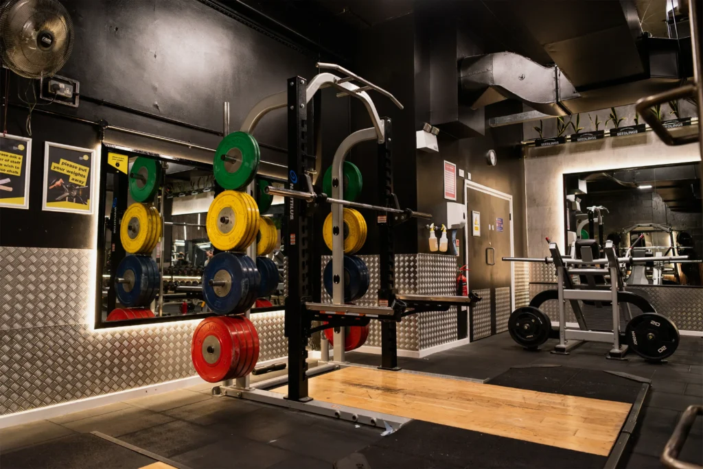 Weight rack stacked with colourful Olympic bumper plates inside Avoya Fitness.