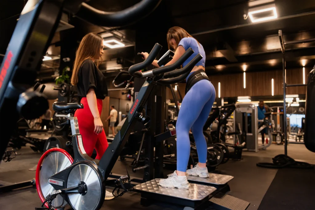 Woman exercising on a belt squat machine in blue athletic wear.